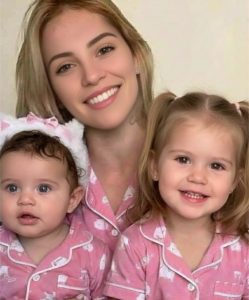 Young woman puts both daughters inside the ..